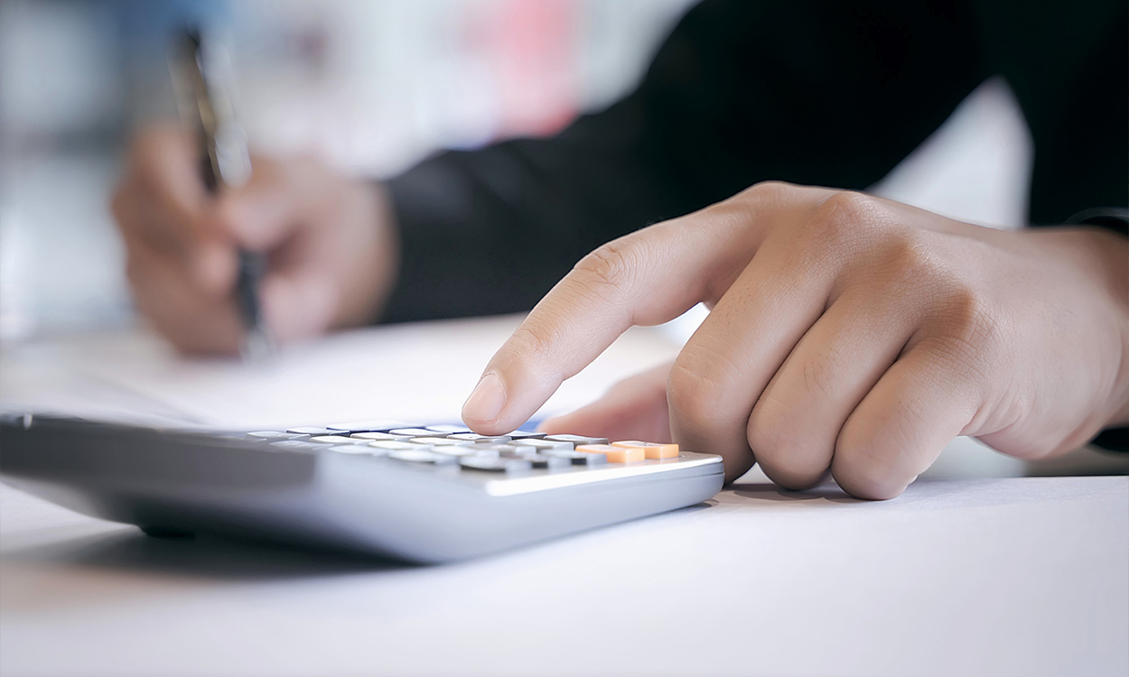 Gros plan sur une main qui tape sur une calculatrice