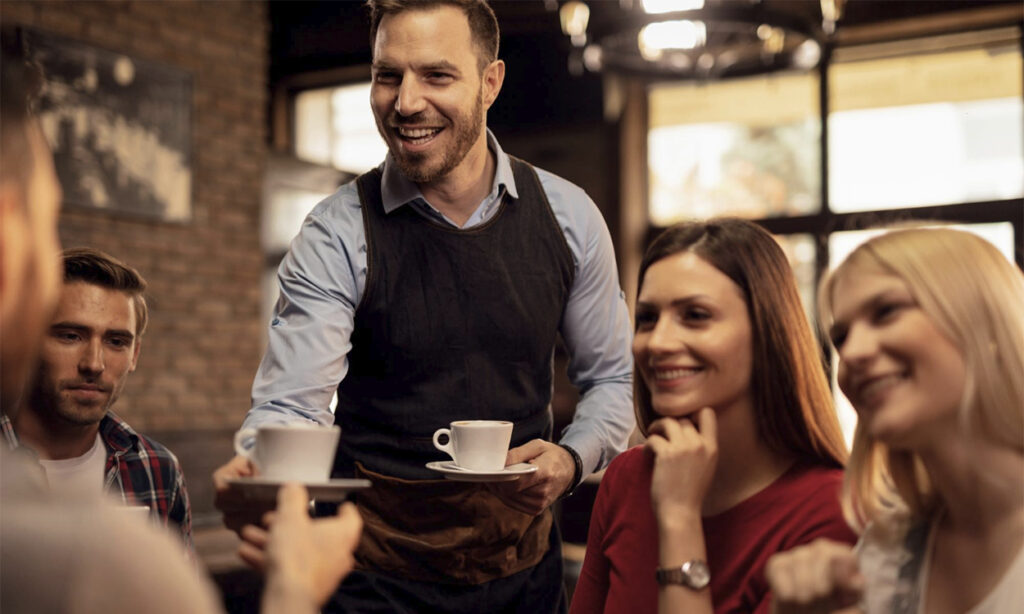 Un serveur apporte le café à une table de restaurant à la fin du repas