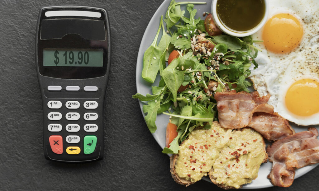TPE posé à côté d'une assiette garnie sur une table de restaurant